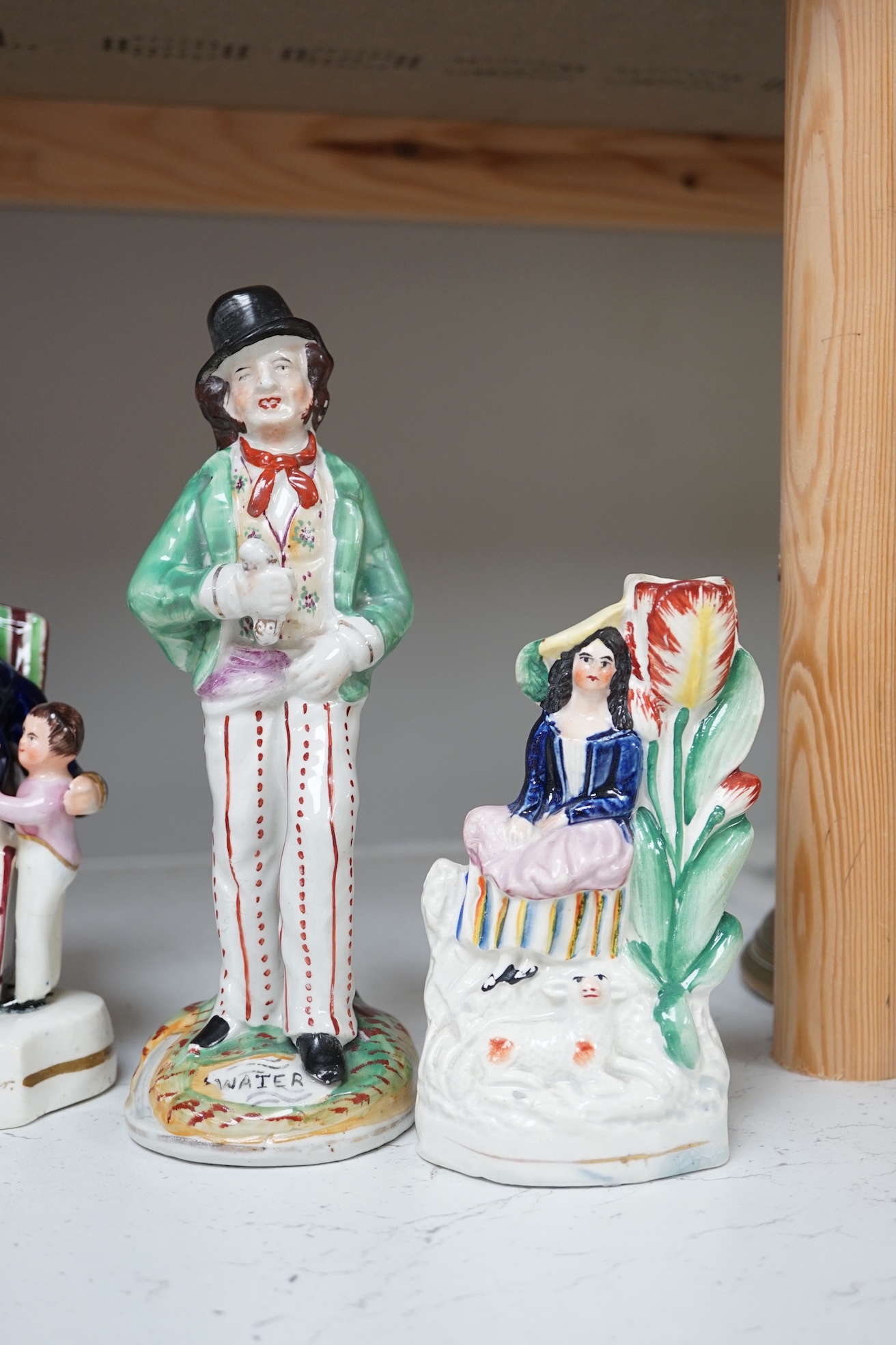 Six mid 19th century Staffordshire figures or groups: a pair titled ‘my grandmother and my grandfather’, a double sided water/gin figure, a pair of figural spill vases and a pearlware group titled ‘Departure’, the talles